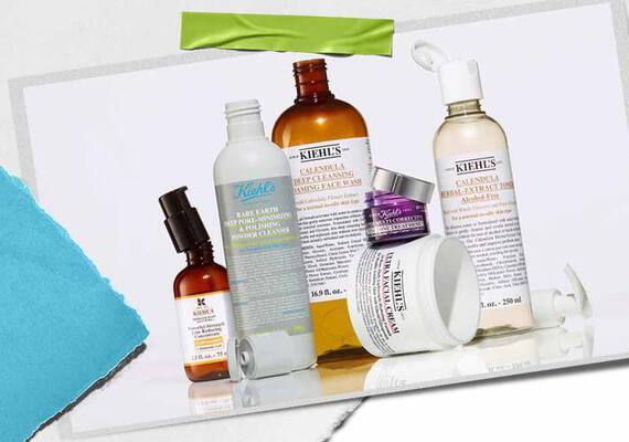 En samling av Kiehl's hudpleieprodukter, inkludert serum, rensemidler og fuktighetskremer, vist på en teksturert bakgrunn.