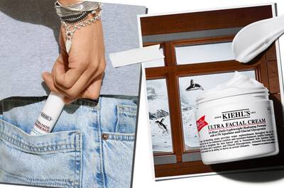 A hand holding a tube of Kiehl's Ultra Facial Cream is shown in a pocket of denim jeans, next to an image of the cream jar and a snowy mountain scene through a window.