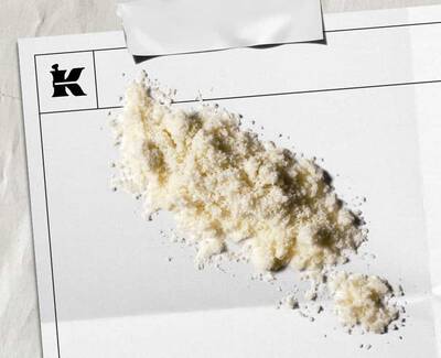 En haug med hvitt pulver på et blankt ark med en logo i hjørnet, som antyder en kunstnerisk eller stilistisk presentasjon.