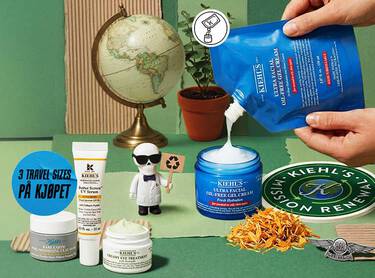 Hender som heller Kiehl's Ultra Facial Oil-Free Gel Cream med andre Kiehl's hudpleieprodukter, en globus, en plante og en liten figur på grønn bakgrunn.