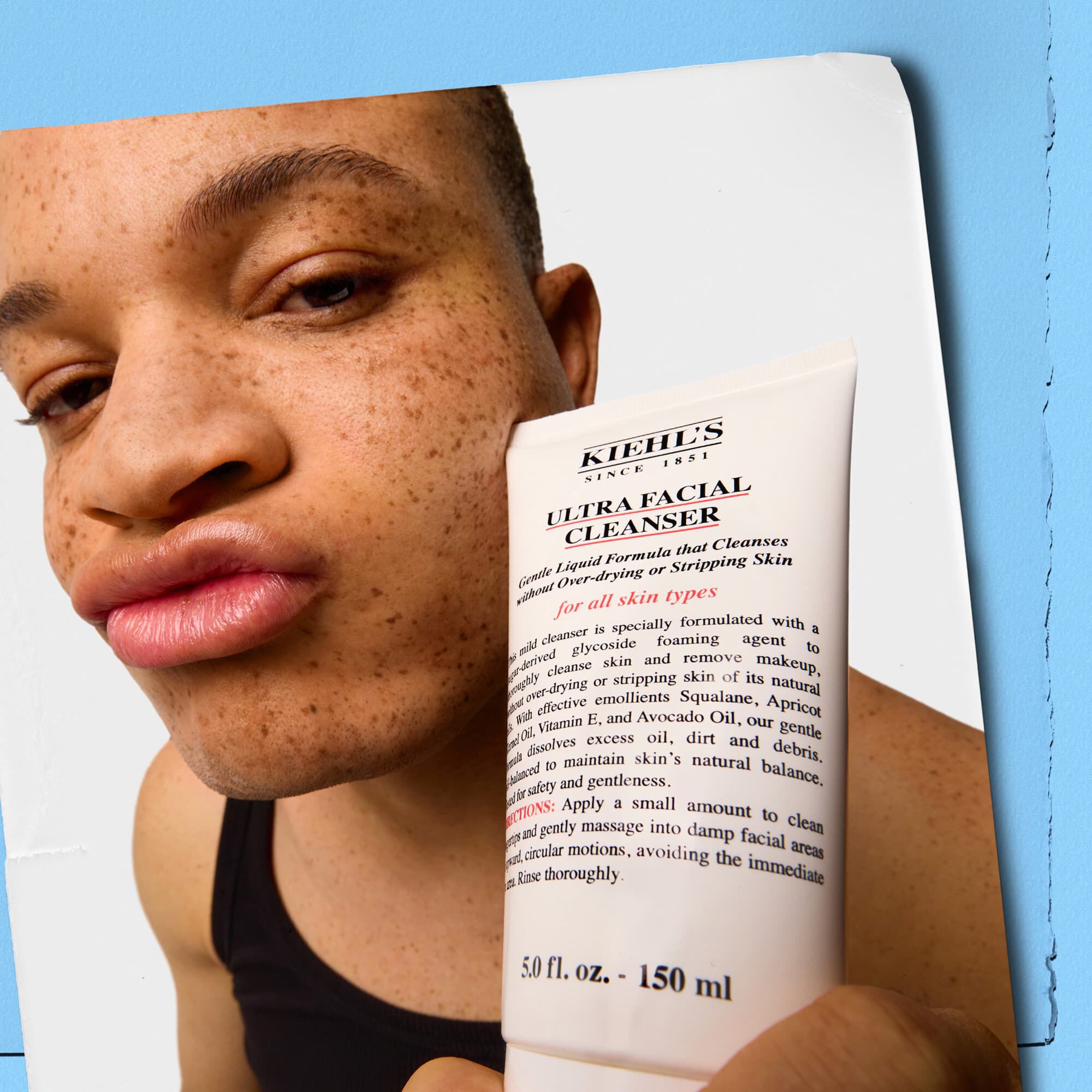 Modell som holder en tube med Kiehl's Ultra Facial Cleanser