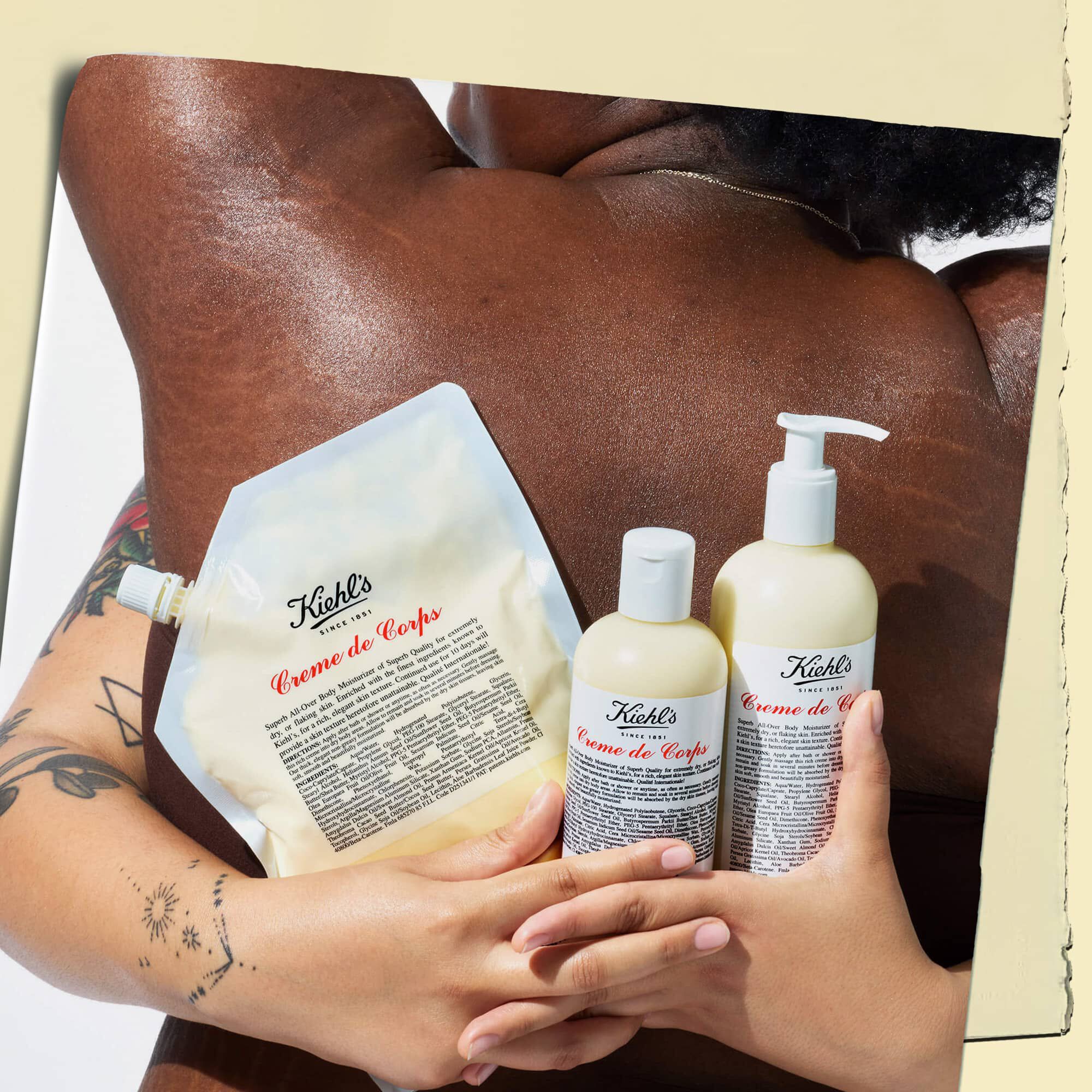 To modeller som omfavner hverandre og holder tre flasker Creme de Corps i ulike størrelser