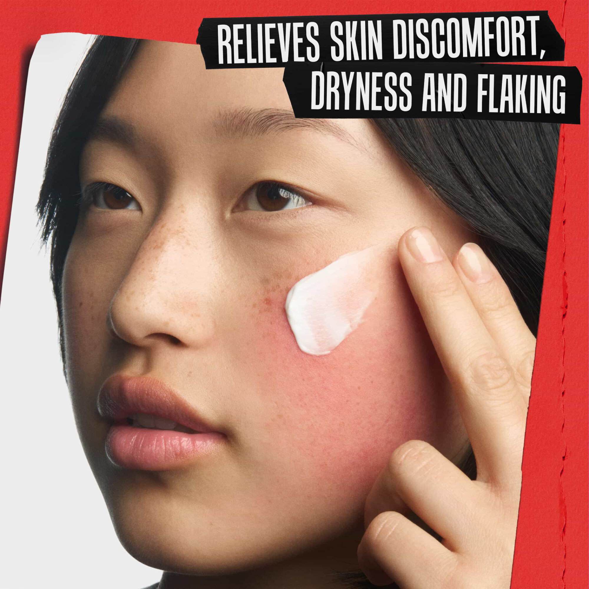 Naerbilde av gjenoppbyggende krem som påføres et irritert kinn. Teksten lyder: LINDRER UBEHAG I HUDEN, TØRRHET OG FLASSING.