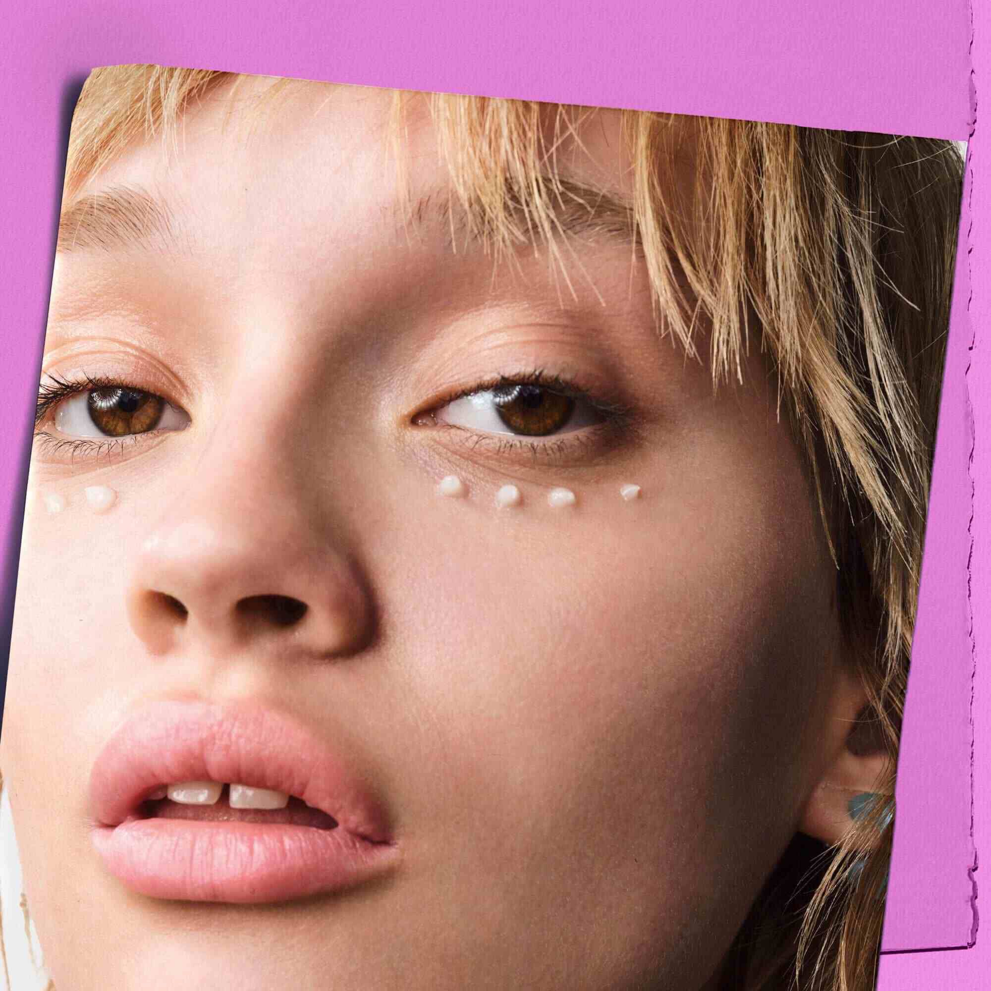 Modell med prikker av Kiehl's Super Multi-Corrective Eye Zone Treatment under øynene