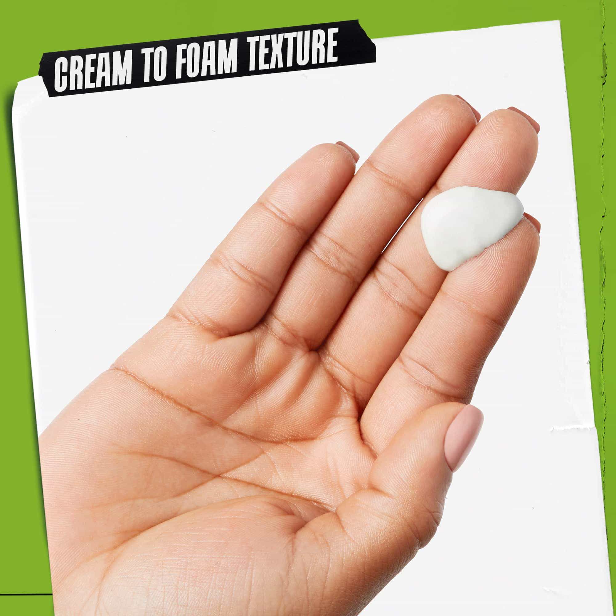 En hånd med Rare Earth Deep Pore Daily Cleanser på. Teksten fremhever "Krem-til-skum-tekstur".
