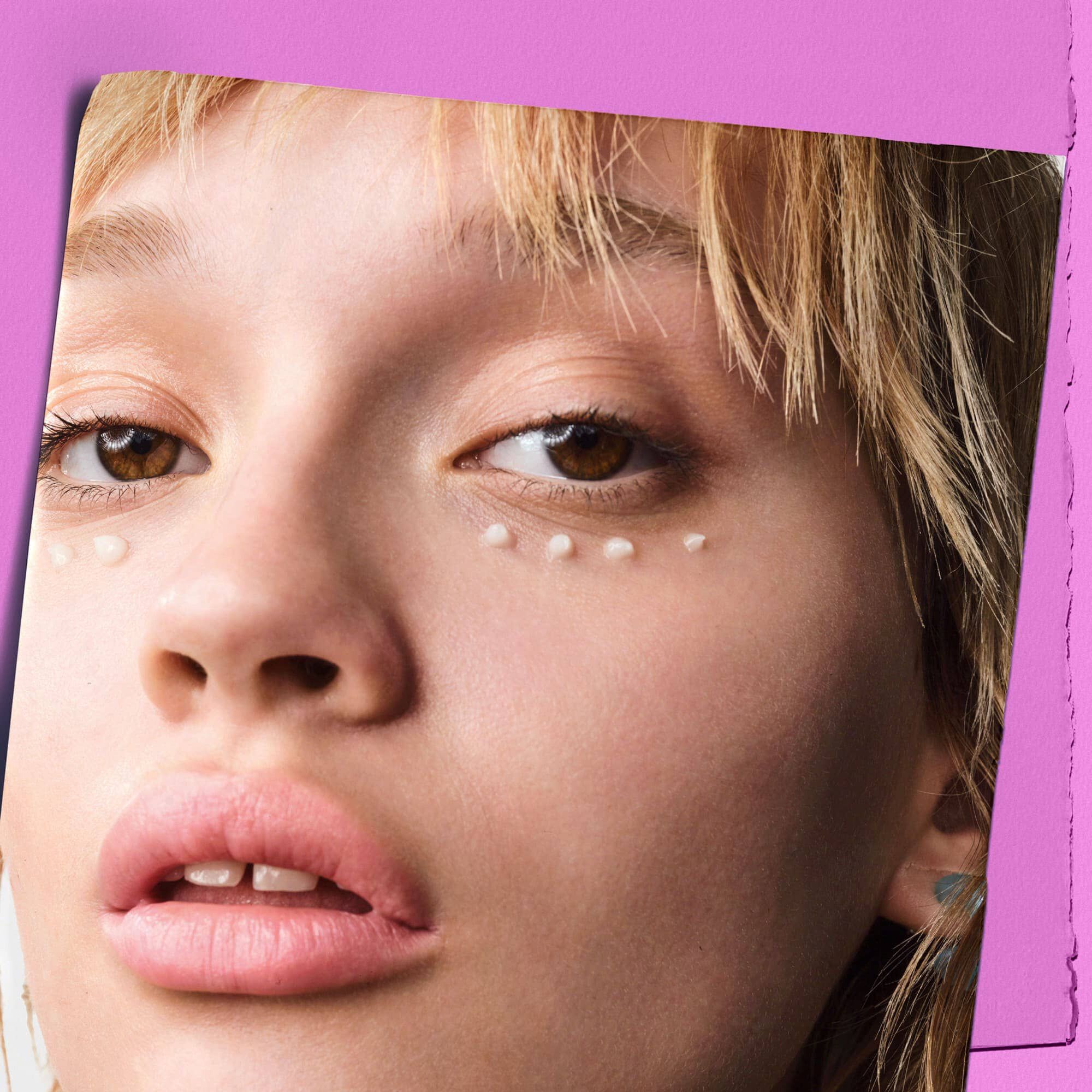 Modell med prikker av Kiehl's Super Multi-Corrective Eye Zone Treatment under øynene