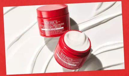 To åpne røde glass med Kiehl's Ultra Facial Meltdown Recovery Cream vist på en hvit bakgrunn med glatte kremfargede virvler, satt mot en rød kant.