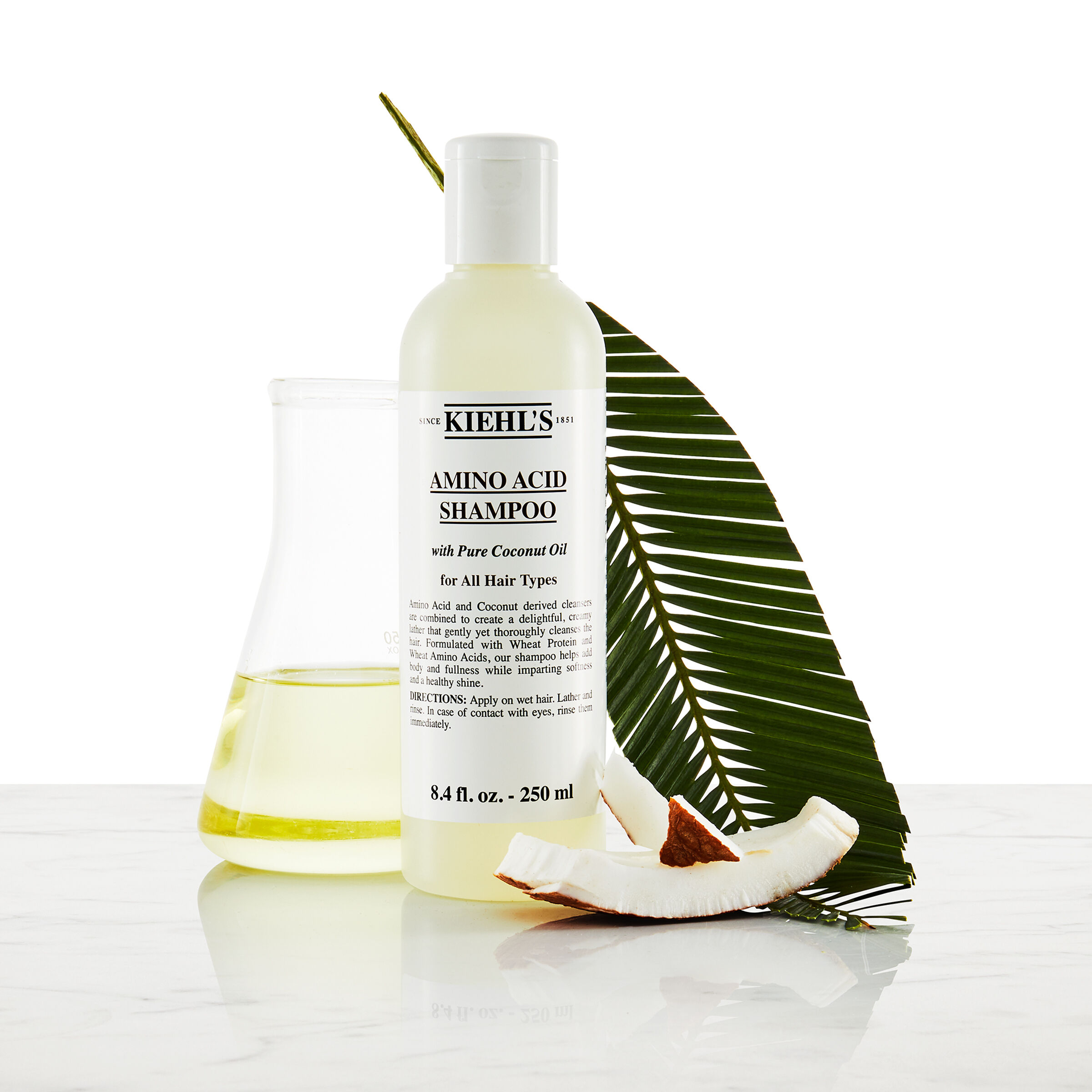 Modell med bart og en flaske Kiehl's Amino Acid Shampoo