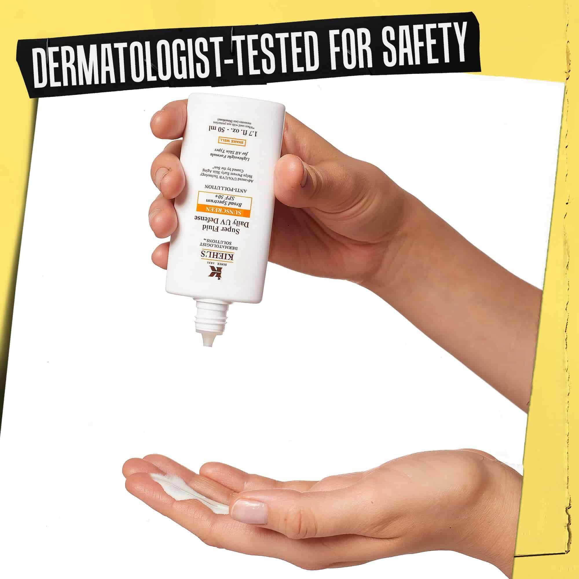 Hånd som Ultra-Light Daily UV Defense doseres på, merket "Dermatologisk testet for sikkerhet".