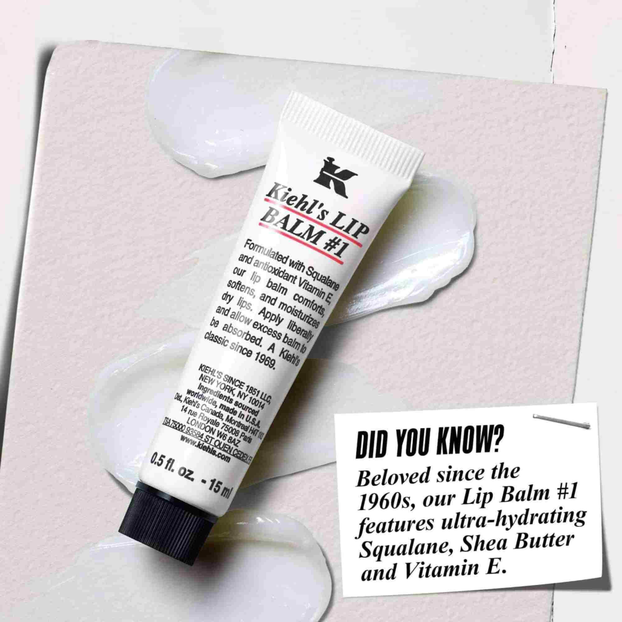 En tube Lip Balm #1 på en hvit overflate med teksten "Visste du at? Formulert med Squalane, Sheasmør og vitamin E for fuktede, glattere lepper."