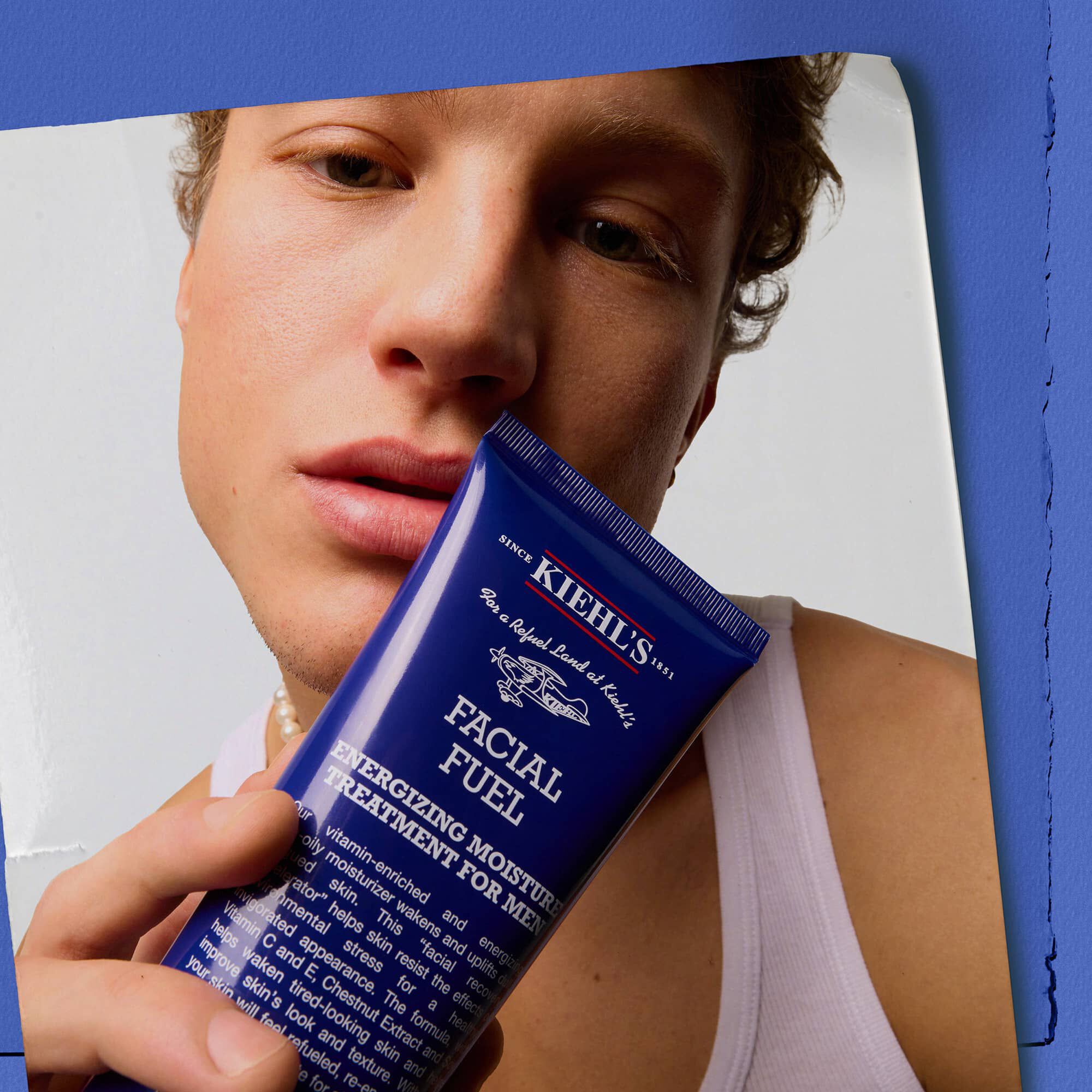 Modell som holder Kiehl's Facial Fuel Energizing Moisture Treatment for menn ansiktskrem