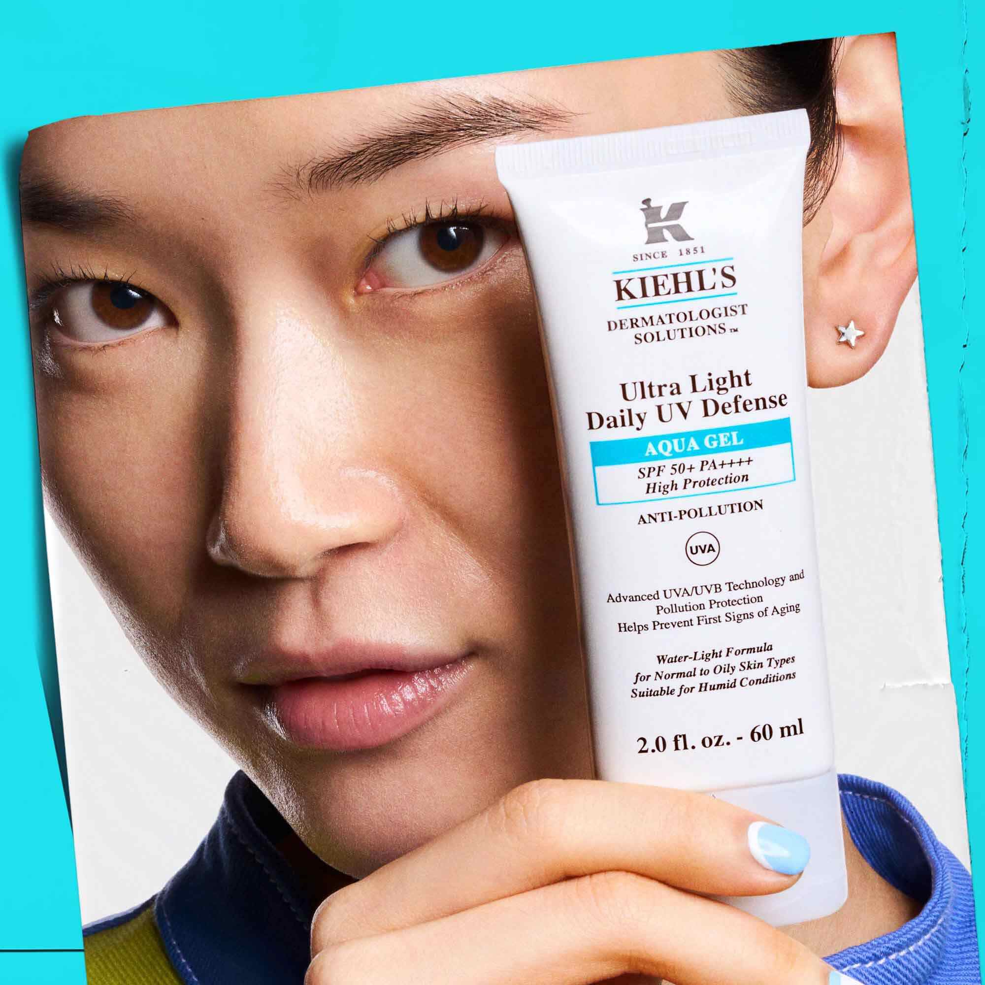 En modell som holder en tube Ultra Light Daily UV Defense Aqua Gel, som viser baerbarhet og brukervennlighet.