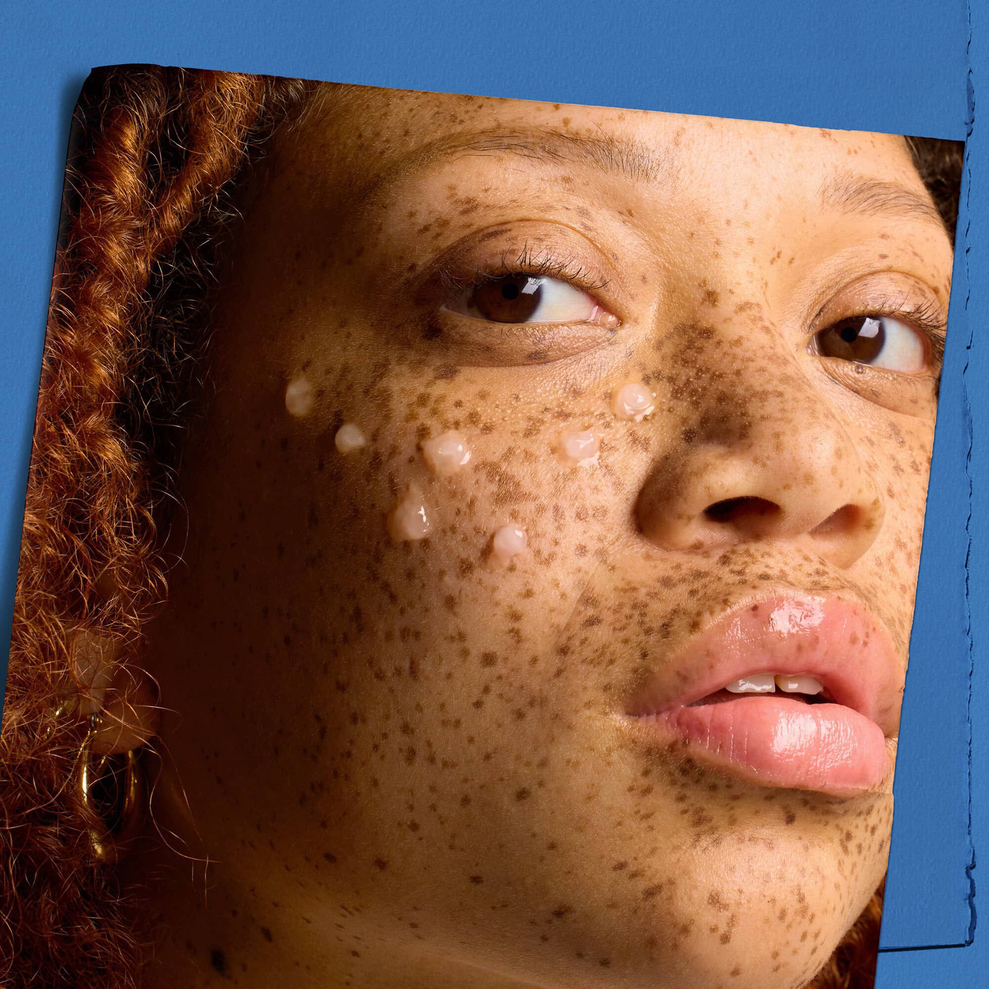 Modell med dråper av Kiehl's Hydro Plumping Serum Concentrate i ansiktet