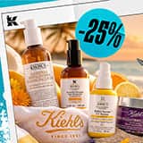 Kiehl's hudpleieprodukter, inkludert ansiktsvask, serum og krem med 25% rabattmerke, mot en solnedgang på stranden.