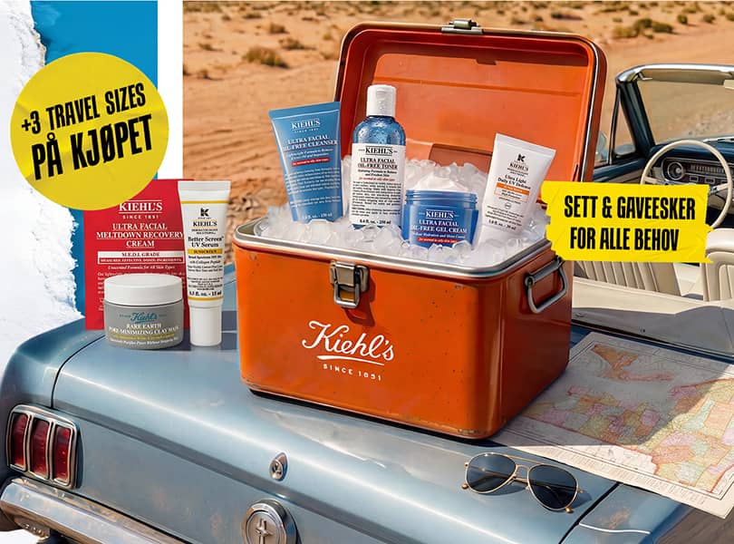 Set Kiehl's Oil-Free Essentials dans une glacière vintage sur une voiture bleue, entouré de glace et d'une carte.